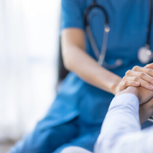 Cropped shot of a female nurse hold her senior patient's hand. Giving Support. Doctor helping old patient with Alzheimer's disease. Female carer holding hands of senior man